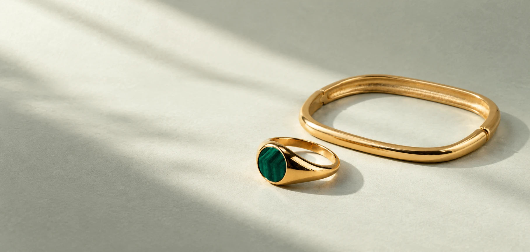 Volaea malachite signet ring and gold square bangle in soft afternoon light
