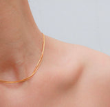 woman wearing two layers of gold chain necklace