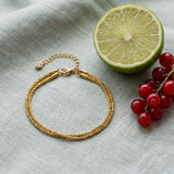 Double Layer Diamond on pale grey-green linen beside a halved lime and red currants