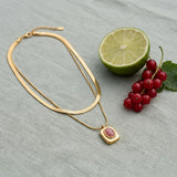 Eve Layered Necklace on pale grey-green linen beside a halved lime and red currants