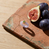 Lyla White Jade Band Ring on a weathered terracotta tile with a cut fig and dark plums