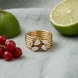 Pear Cluster Ring on pale grey-green linen beside a halved lime and red currants