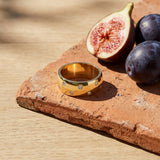 Stellar Band on a weathered terracotta tile with a cut fig and dark plums