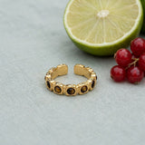 Tiger's Eye Band Ring on pale grey-green linen beside a halved lime and red currants