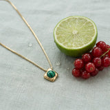 Wade Malachite Necklace on pale grey-green linen beside a halved lime and red currants