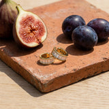 White Baguette Ear Cuff on a weathered terracotta tile with a cut fig and dark plums